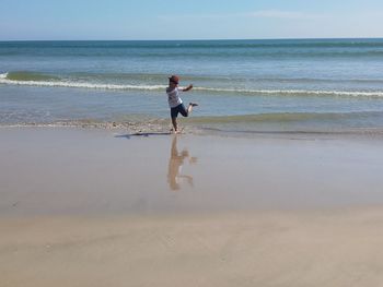 Full length of woman on beach against sky