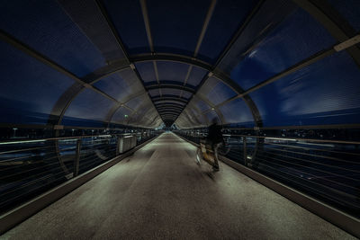 Rear view of man walking on bridge