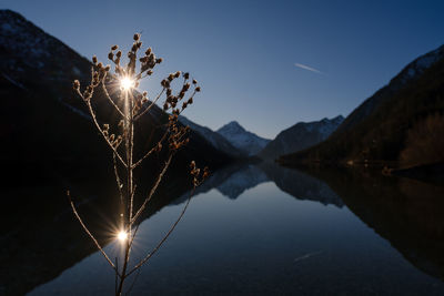 Scenic view of lake by mountains against sky