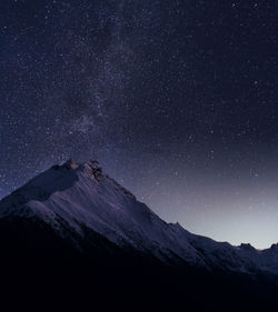 Scenic view of mountains against star field at night