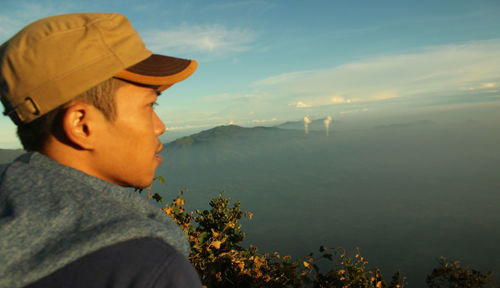 Portrait of man looking at mountains against sky