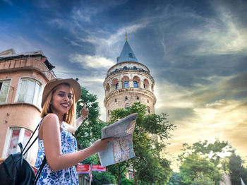 Low angle view of woman against building against sky