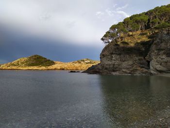 Rock formations by sea against sky