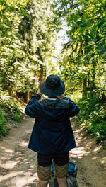 Rear view of woman standing in forest