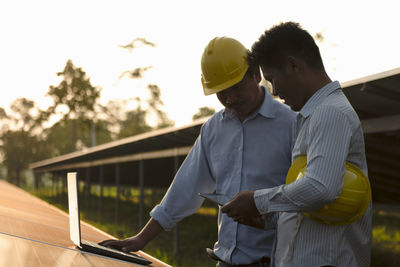 Side view of man standing against building