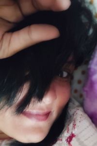 Close-up portrait of young woman lying on bed