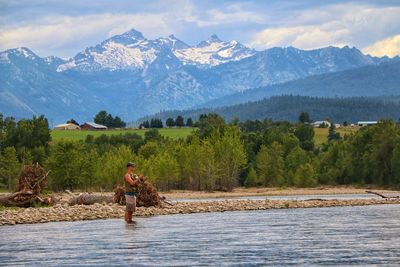 Full length of man on lake against mountain range