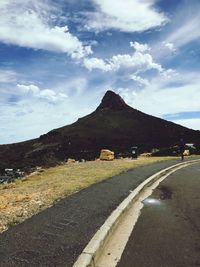 Road by mountains against sky