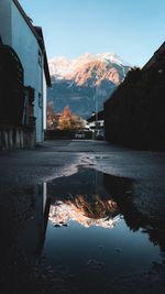 Reflection of buildings on mountain against sky