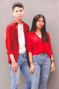 Portrait of smiling friends standing against wall