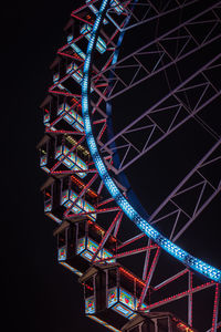 Low angle view of illuminated ferris wheel against sky at night