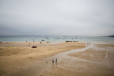 People on beach against sky