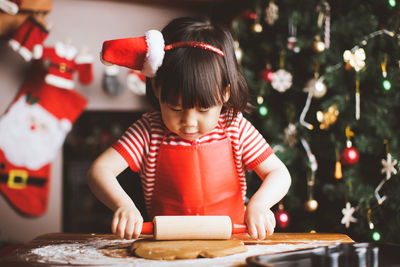 Girl making cookies at table during christmas