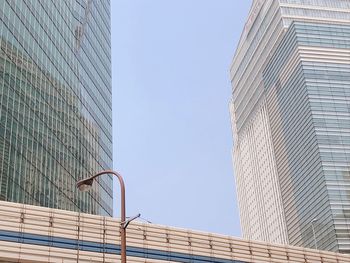 Low angle view of modern buildings against clear blue sky