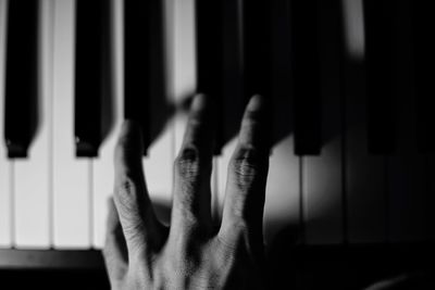 Cropped hand playing piano