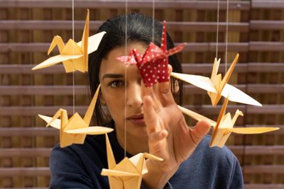 Portrait of woman playing with origami decoration