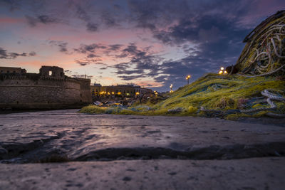 Surface level of fishing net with angevin castle in background during sunset