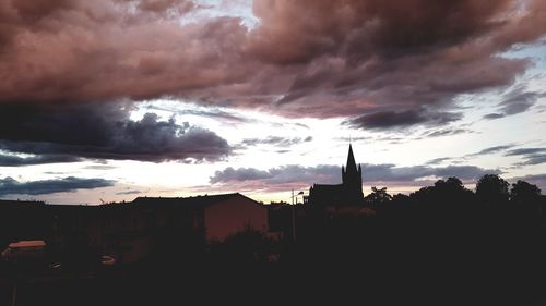 Silhouette buildings against sky during sunset