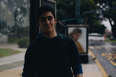 Portrait of young man standing in city