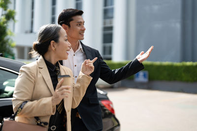 Business colleagues using mobile phone