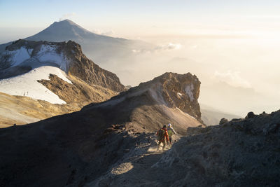 A couple running down from the summit of iztaccihuatl volcano