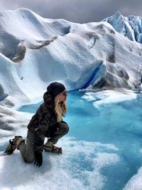 Portrait of mature woman kneeling at glacier 