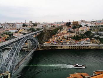 Bridge over river in city against sky