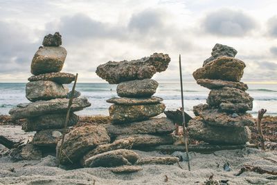 Stack of rocks on beach against sky