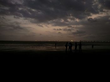 Scenic view of beach against cloudy sky