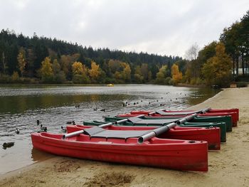 Boats moored in lake against sky