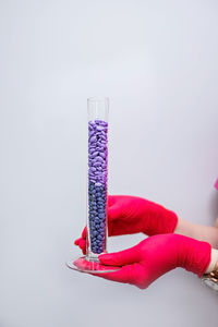 Close-up of hand holding umbrella against white background