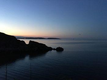 Scenic view of sea against clear sky at sunset