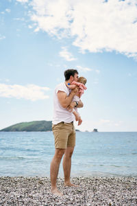 Full length of man standing on beach against sky