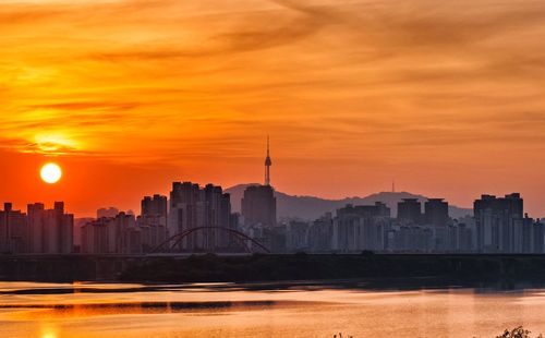 View of buildings against cloudy sky during sunset