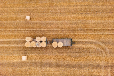 Hay bales stored on two trailers on a harvested agricultural field in summer, drone photo, germany