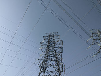 Low angle view of electricity pylon against clear sky