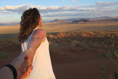 Woman on desert against sky