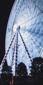 Low angle view of ferris wheel in city at night