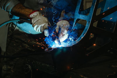 Cropped hand of man welding metal