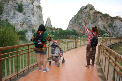 Rear view of people walking on footbridge