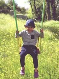 Full length of boy on swing at playground