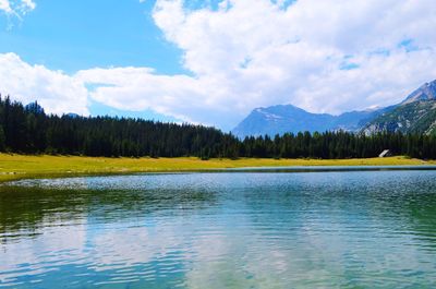 Scenic view of lake by mountains against sky