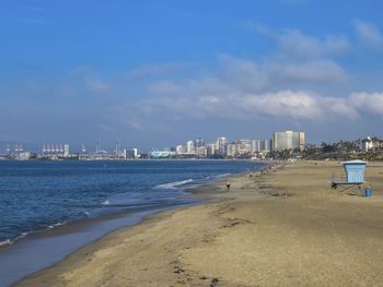 City at waterfront against cloudy sky