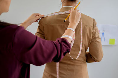 Fashion designer measuring woman at studio