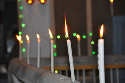 Close-up of illuminated candles against building