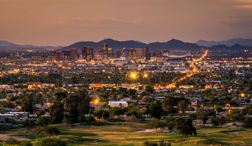 High angle view of illuminated buildings against sky at sunset