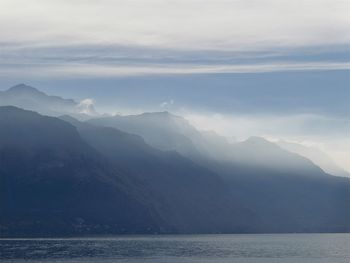 Scenic view of sea and mountains against sky