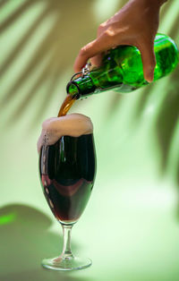 Close-up of hand pouring wine in glass