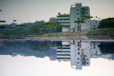 Buildings by lake against sky in city