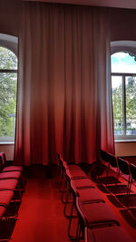 Empty chairs and table against window